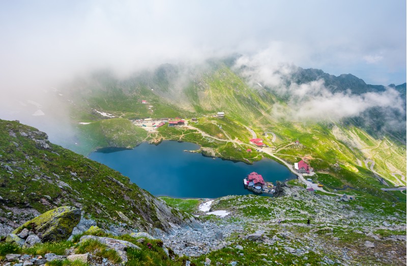 Balea lake view from above. beautiful landscape in Fagaras mountains with rising cloud on summer day
