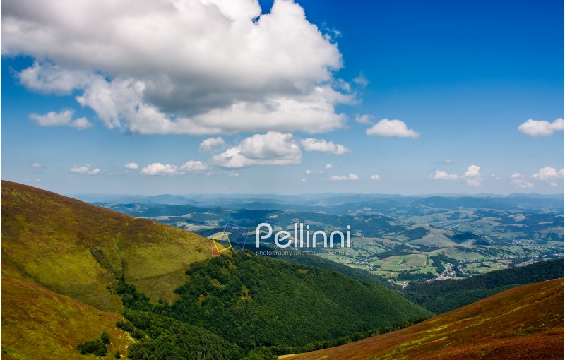 Carpathian Mountains with its peaks, hills, meadows and forests under the blue sky with clouds in late summer day
