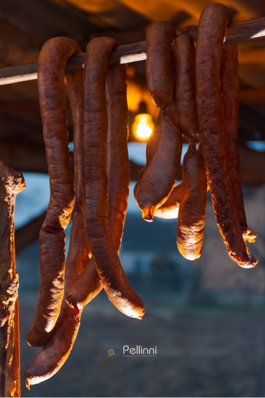 Hecha, Ukraine - JAN 27, 2018: Pork butchers completion. Smoke-dried  sausages hang on the bar. tasty traditional food