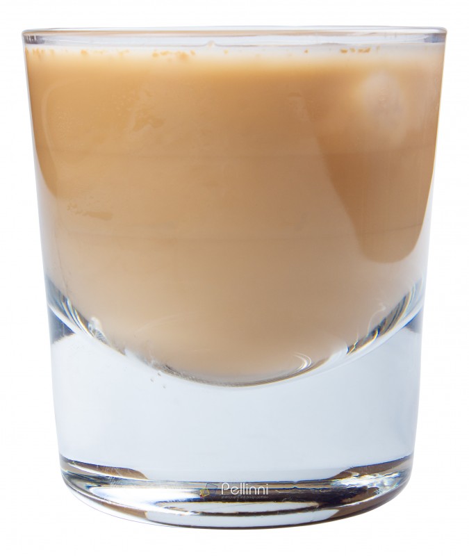 irish cream alcohol cocktail with ice in a short glass. side view isolated on a white background