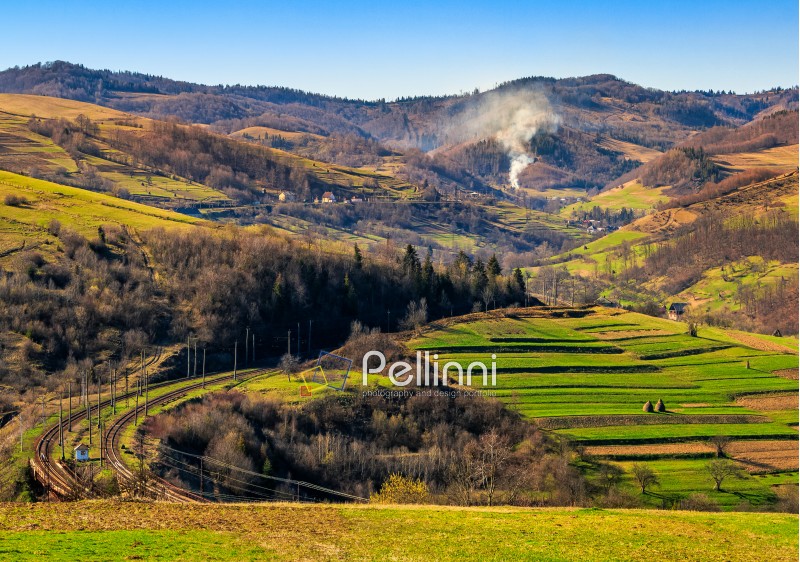Spring time rural landscape. Railroad winds through agricultural fields in Carpathian mountains