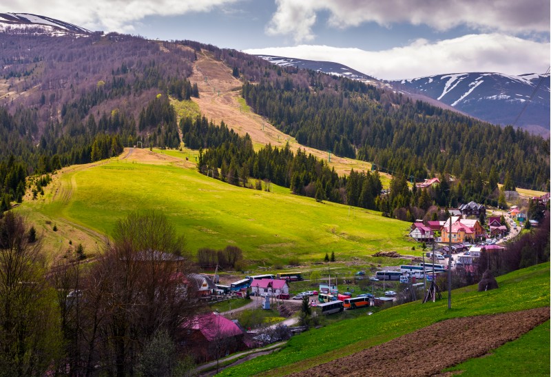 Pylypets, Ukraine - May 01, 2017: Tourist buses in Pylypets resort village. beautiful springtime landscape in Carpathian mountains