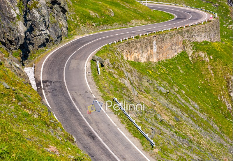 Transfagarasan road in Romanian mountains. winding serpentine among the grassy hills on a sunny morning