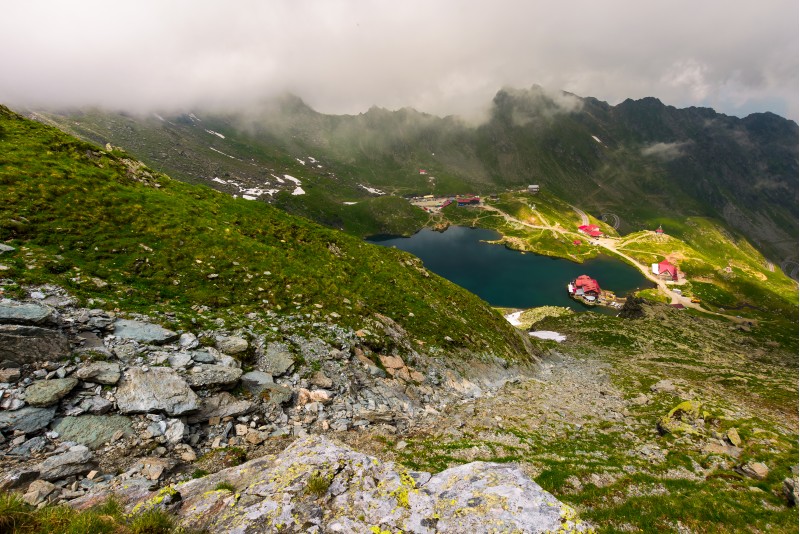 area of lake Balea in clouds. Gorgeous summer landscape of Fagarasan mountains, Romania. popular tourist location observed from the top of the ridge