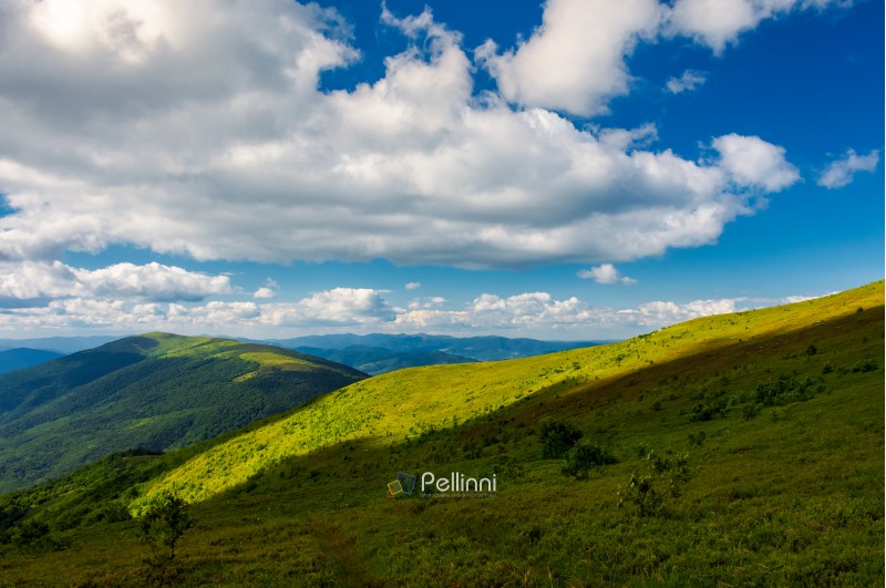 beautiful mountainous landscape under the summer sky. fluffy clouds over the mountain ridge. light on the nearest hill. pleasant atmosphere and good day for a hike. lovely nature background