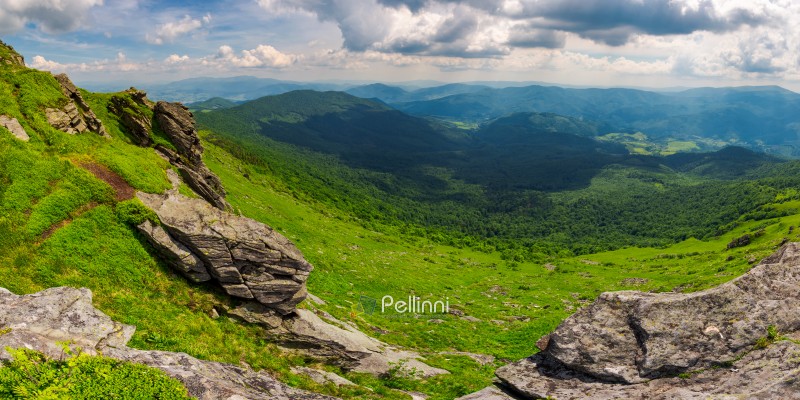 beautiful panorama of mountainous landscape. view from the edge of a hillside with cliffs. Borzhava ridge and Runa mountain in the distance. village down in the valley. lovely summer scenery