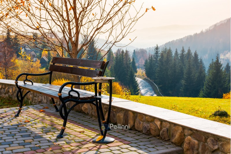 bench on a hill in beautiful autumn countryside. lovely mountainous landscape with road through forest