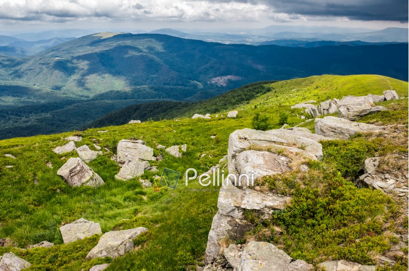 boulders on a green grassy slope of mountain ridge. beautiful summer landscape of Carpathians before the storm