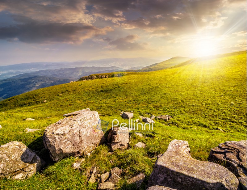 white sharp boulders on the hillside meadow with green grass in high Crapathian mountains in evening light
