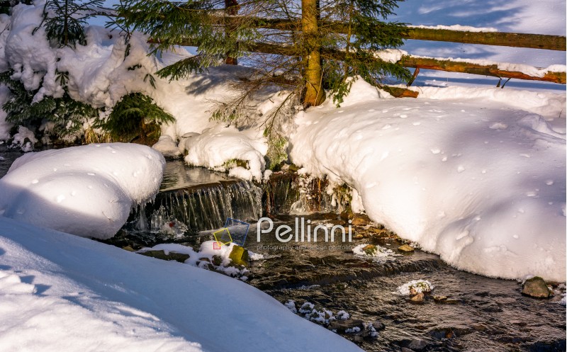 brook with cascades in winter forest. lovely winter nature scenery