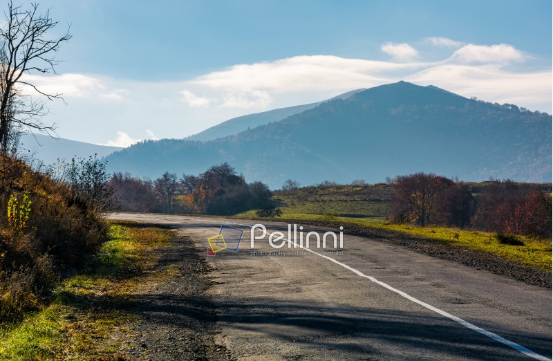 countryside road in autumnal mountainous area. beautiful view of high mountain in the distance in fine forenoon weather