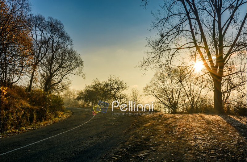 countryside road in late autumn fog at sunrise. dangerous transportation area in mountains