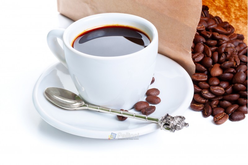 white cup of black coffee near the laying paper bag with coffee beans
