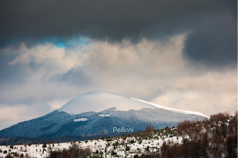 dramatic sky above the distant snowy peak. beautiful winter scenery