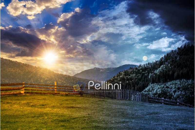 day and night time change concept. wooden fence through the grassy meadow in mountains. beautiful Carpathian countryside landscape with cloudy sky with sun and moon