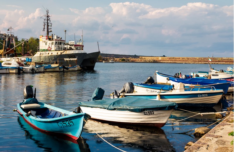 SOZOPOL - AUGUST 19: fishing boats at sunset on August 19, 2015 in Sozopol, Bulgaria. small fishing boats and few big one docked near embankment in port of Bulgarian town Sozopol in evening light