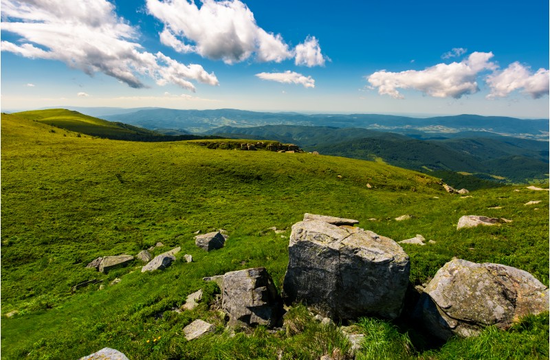 gorgeous mountain landscape on a summer day. giant boulders on a grassy hillside under the beautiful sky with clouds. 