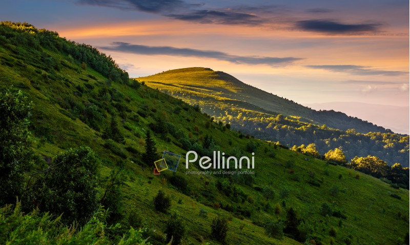 mountain ridge with peak behind the hillside. beautiful summer background at sunset with red sky