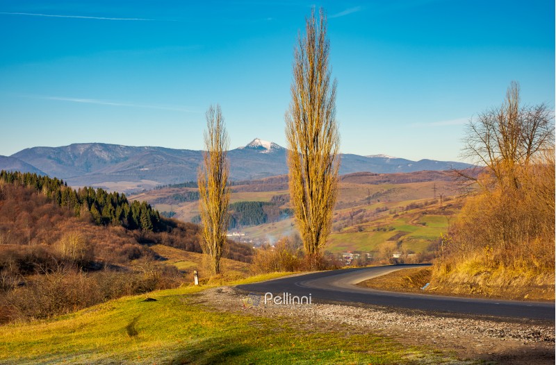 new asphalt road in to the mountains. Pikui mountain with snowy top in the distance. beautiful sunny weather in late autumn. location Volovets serpentine, TransCarpathia, Ukraine
