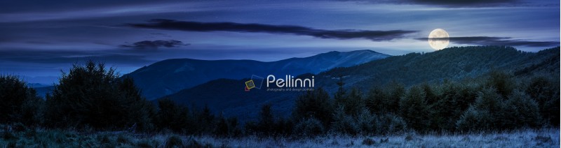 panorama of Carpathian mountains at night in full moon light. beautiful landscape with forested hills and Apetska mountain in the distance. 