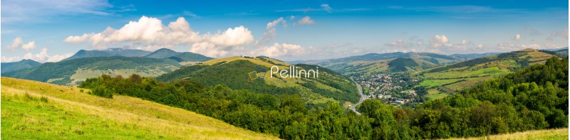 panorama of beautiful mountainous rural area. village down in the valley. agricultural fields on hills
