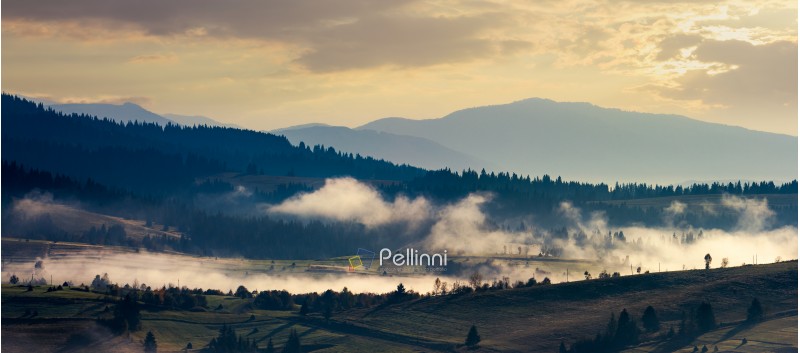 panorama of countryside in the morning. beautiful landscape in mountains with fog rising above the valley and hill