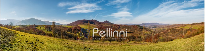 panorama of mountainous rural area in autumn. beautiful countryside with mountain ridges and forest with red foliage on hillsides