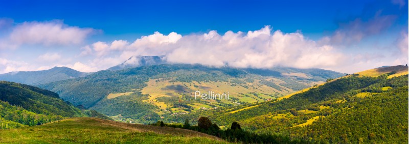 panorama of mountainous rural area in autumn. lovely countryside scenery with fluffy clouds above the ridge