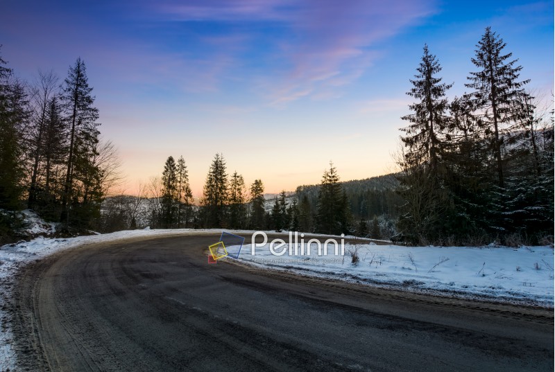 red dawn on serpentine in winter forest. beautiful nature scenery in mountains. lovely transportation background
