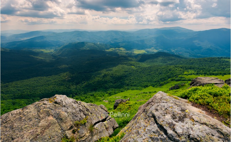 rocks on the edge of a  mountain. location Pikui mountain. Runa mountain in the far distance. Beautiful summer landscape of Carpathian mountains on a cloudy day