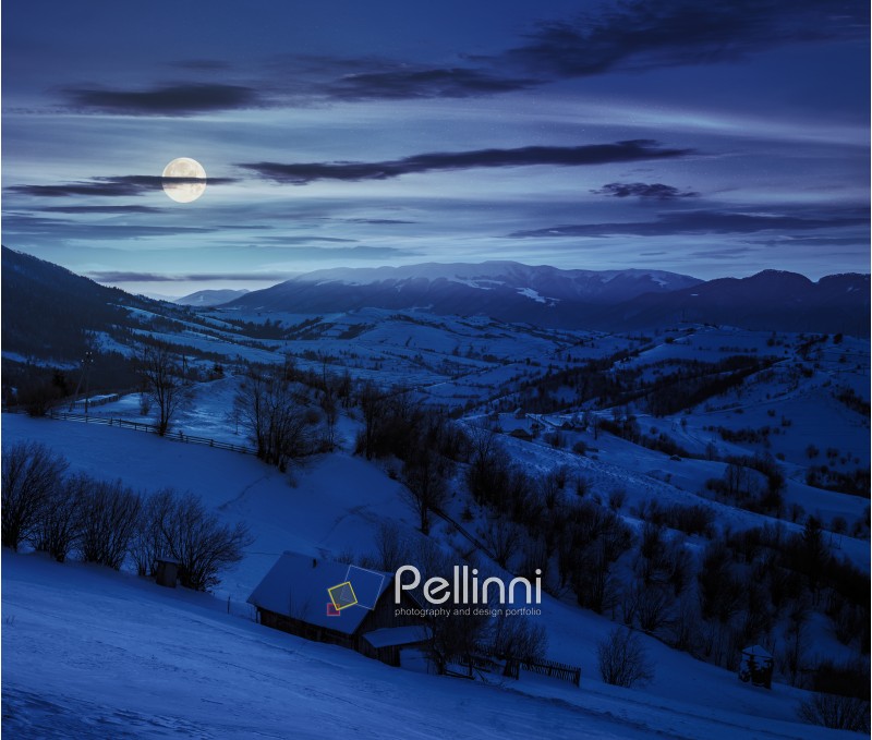 few houses of village on hillside in mountain area at night in full moon light