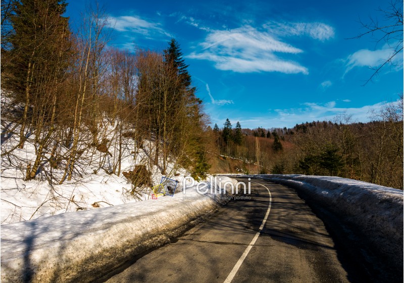 turnaround on the mountain road in winter. forested hills with snow on roadside under the clear blue sky