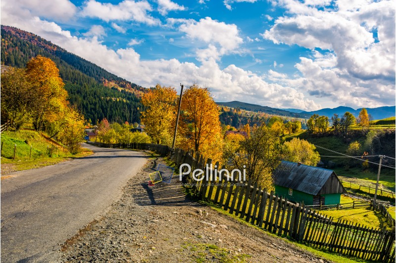 winding road through village in mountains. beautiful Carpathian rural scenery. gorgeous afternoon autumn weather with stunning sky