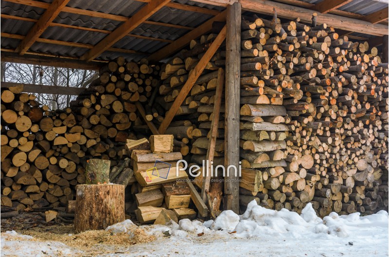woodshed full of chopped firewood. beautiful scene of everyday rural life in winter. ecological energy concept