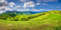 Idyllic view of pretty farmland rolling hills. Rural landscape near the forest in mountains.