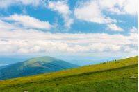 beautiful summer landscape in mountains. sunny weather with gorgeous cloudscape on a blue sky. grassy green slope.