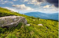 boulder on the grassy hillside. beautiful mountain landscape