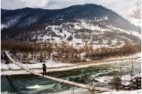 cold flow of river in snowy mountains. ice and snow on the rocky shore. gorgeous winter scenery in rural area on a cloudy day. 