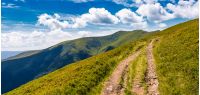 footpath through panorama of grassy mountain ridge. beautiful summer landscape under gorgeous sky with clouds
