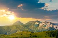 landscape in mountains with rocky formations. grassy meadows, forested hills and huge cliffs. wonderful nature scenery. beautiful weather at sunset in springtime