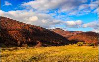 mountain landscape in autumn season. beautiful and vivid countryside with blue sky and clouds.