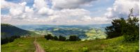 panorama of beautiful landscape in mountains. gorgeous view from Borzhava mountain ridge. road down the grassy hill to tourist base. wonderful summer weather with cloudy sky