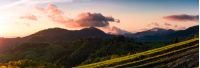 panorama of mountains at sunset. beautiful landscape with purple clouds and green hills in springtime