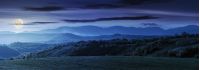 panorama of romania countryside at night in full moon light wonderful springtime landscape in mountains. grassy field and rolling hills. rural scenery