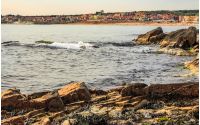 SOZOPOL, BULGARIA - SEPTEMBER 11, 2013: rocky shore and sandy city beach in mellow season. Beautiful and warm weather on the coast of Black sea.