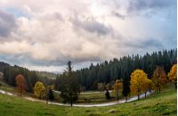 serpentine through forest in autumn. beautiful mountainous landscape with gorgeous cloudscape in evening. creative distortion applied. lovely travel background