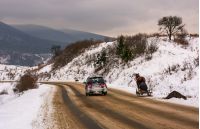 Volovets, Ukraine - December 16, 2016: traffic in mountainous rural area in winter. cart with one horse outscored by SUV on snowy countryside road