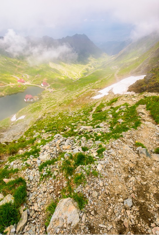 Balea lake in fog view from the top. lovely summer landscape with low clouds around