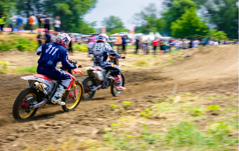 Uzhgorod, Ukraine - May 21, 2017: MX rider turns on a corner. Motion blur with flying dirt. TransCarpathian regional Motocross Championship