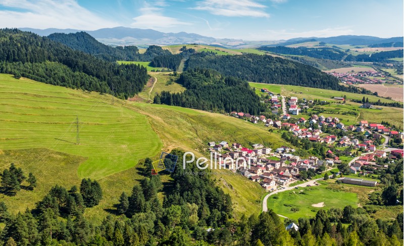 Slovakian town Stara Lubovna on grassy hillside. beautiful rural scenery in mountainous area viewed from above on a summer day. 
